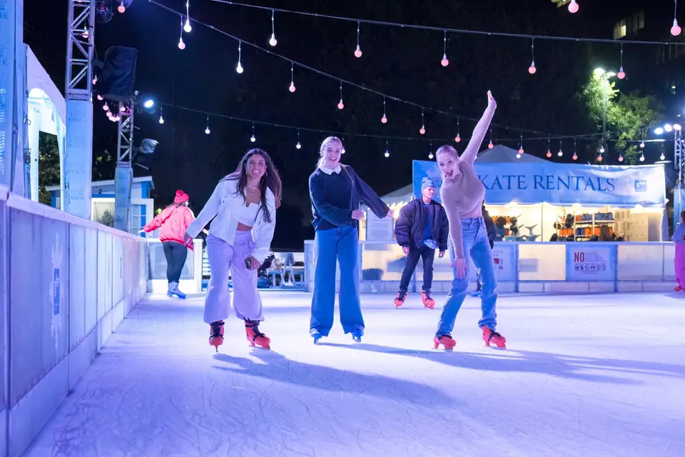 Friends skating together under the evening lights